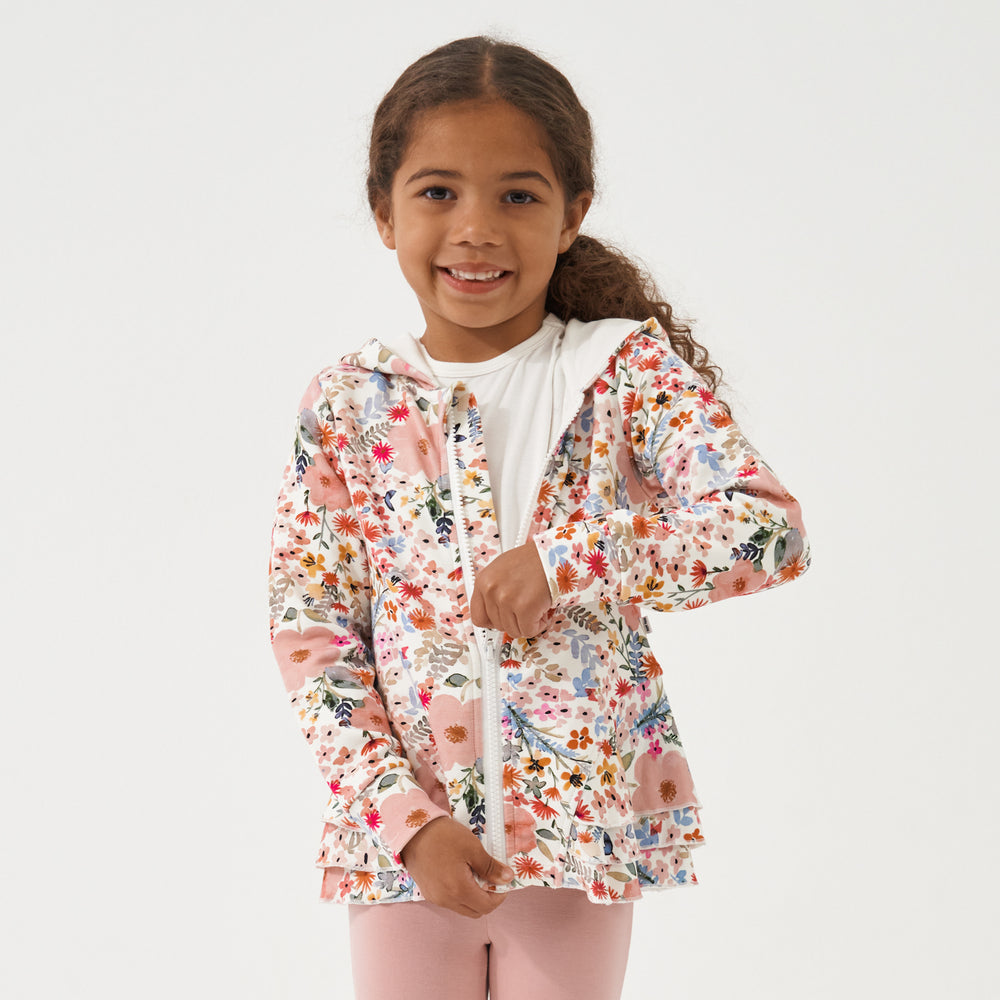 Child zipping up her Mauve Meadow printed peplum hoodie paired with Mauve leggings