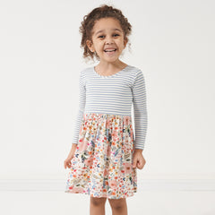 Child wearing an Ivory Fog Stripe and Mauve Meadow skater dress