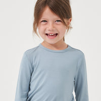 Close up image of a child wearing a Fog classic tee