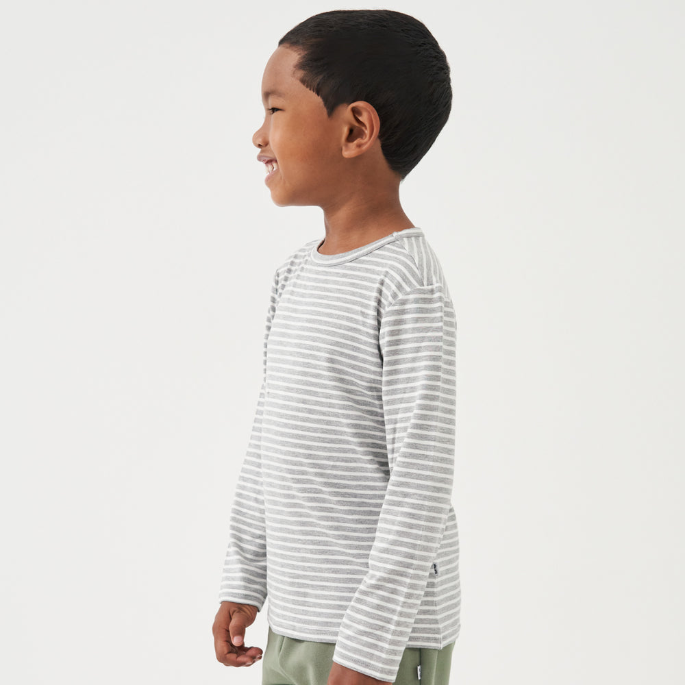 Profile view of a child wearing a Heather Gray and Ivory Stripe classic tee paired with Moss joggers
