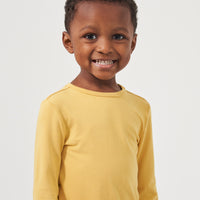 Close up image of a child wearing a Honey classic tee