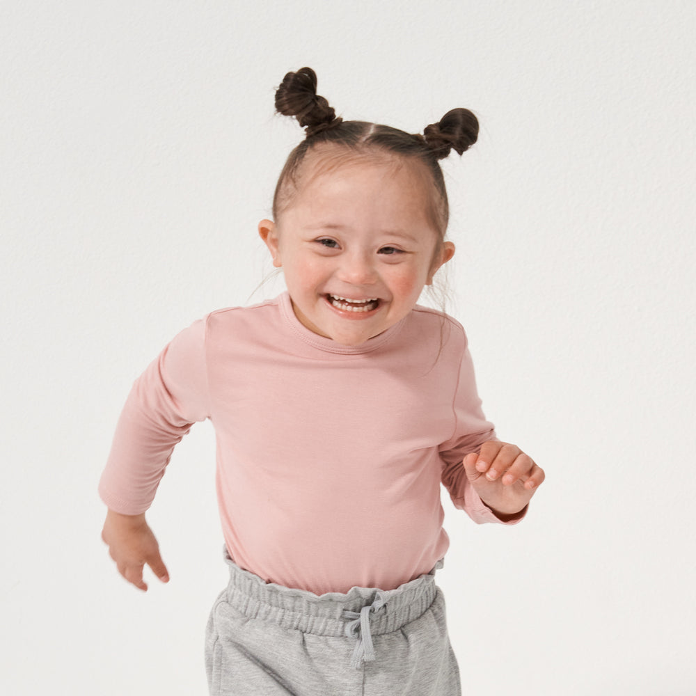 Child playing wearing a Mauve Blush classic tee paired with Heather Gray paperbag joggers