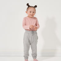 Child wearing Heather Gray paperbag joggers paired with a Mauve Blush classic tee