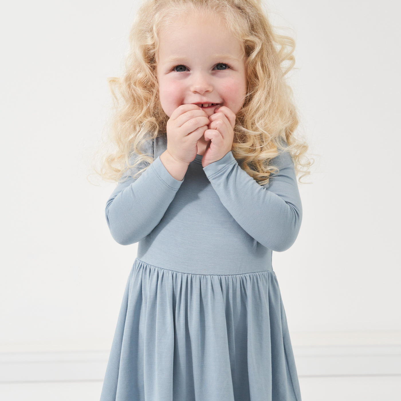 Close up image of a child wearing a Fog twirl dress with bodysuit