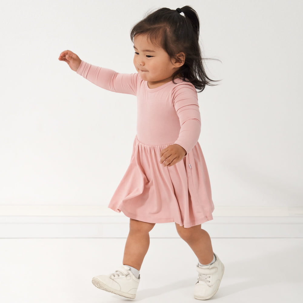 profile view of a child walking wearing a Mauve Blush twirl dress with bodysuit