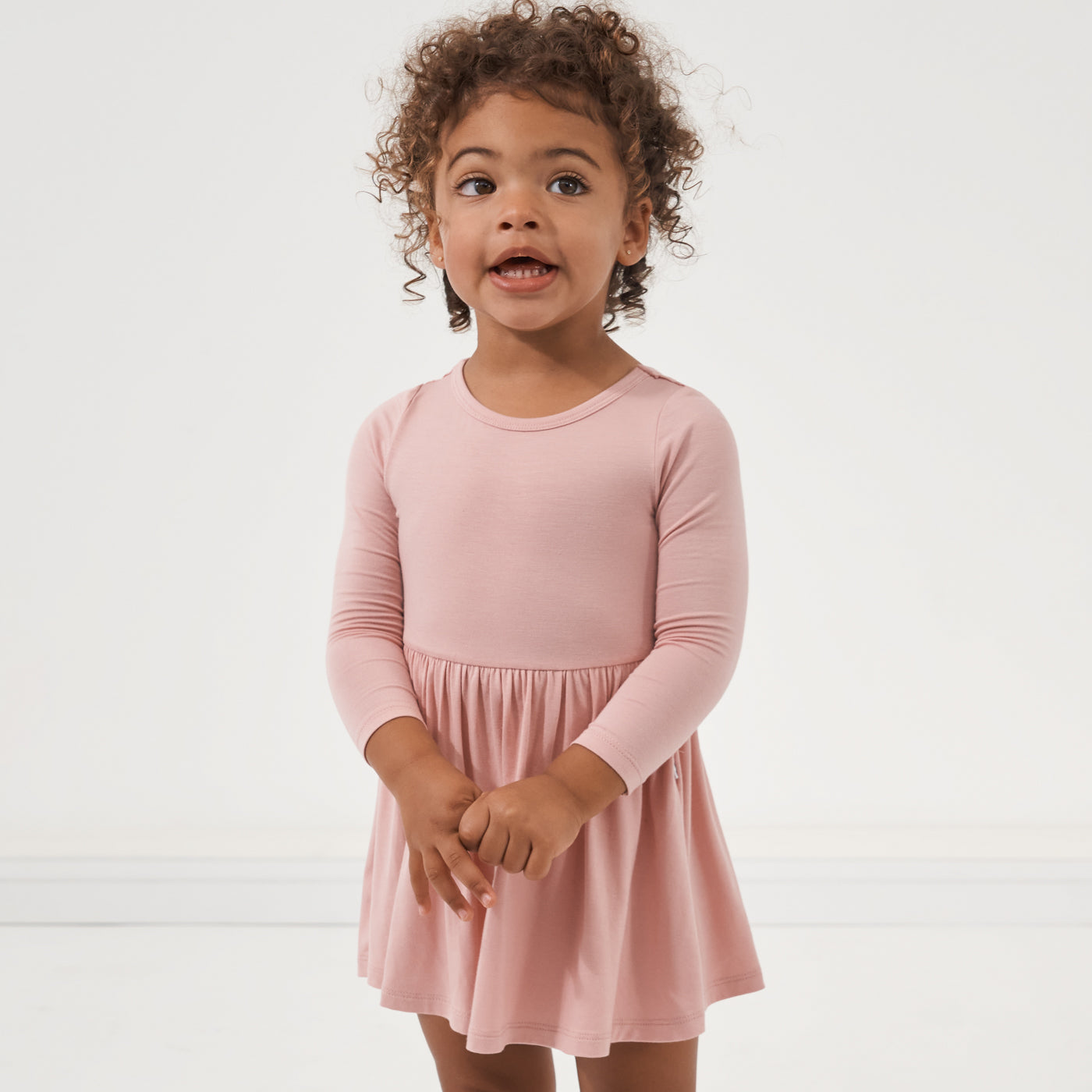 Child posing wearing a Mauve Blush twirl dress with bodysuit