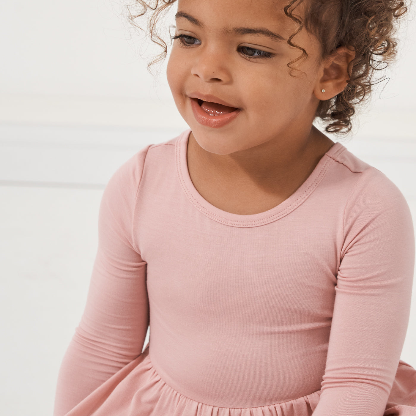 Close up image of a child wearing a Mauve Blush twirl dress with bodysuit