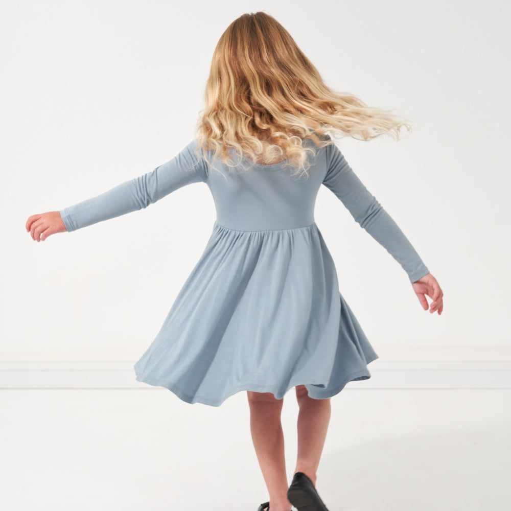 Back view of a child spinning wearing a Fog twirl dress