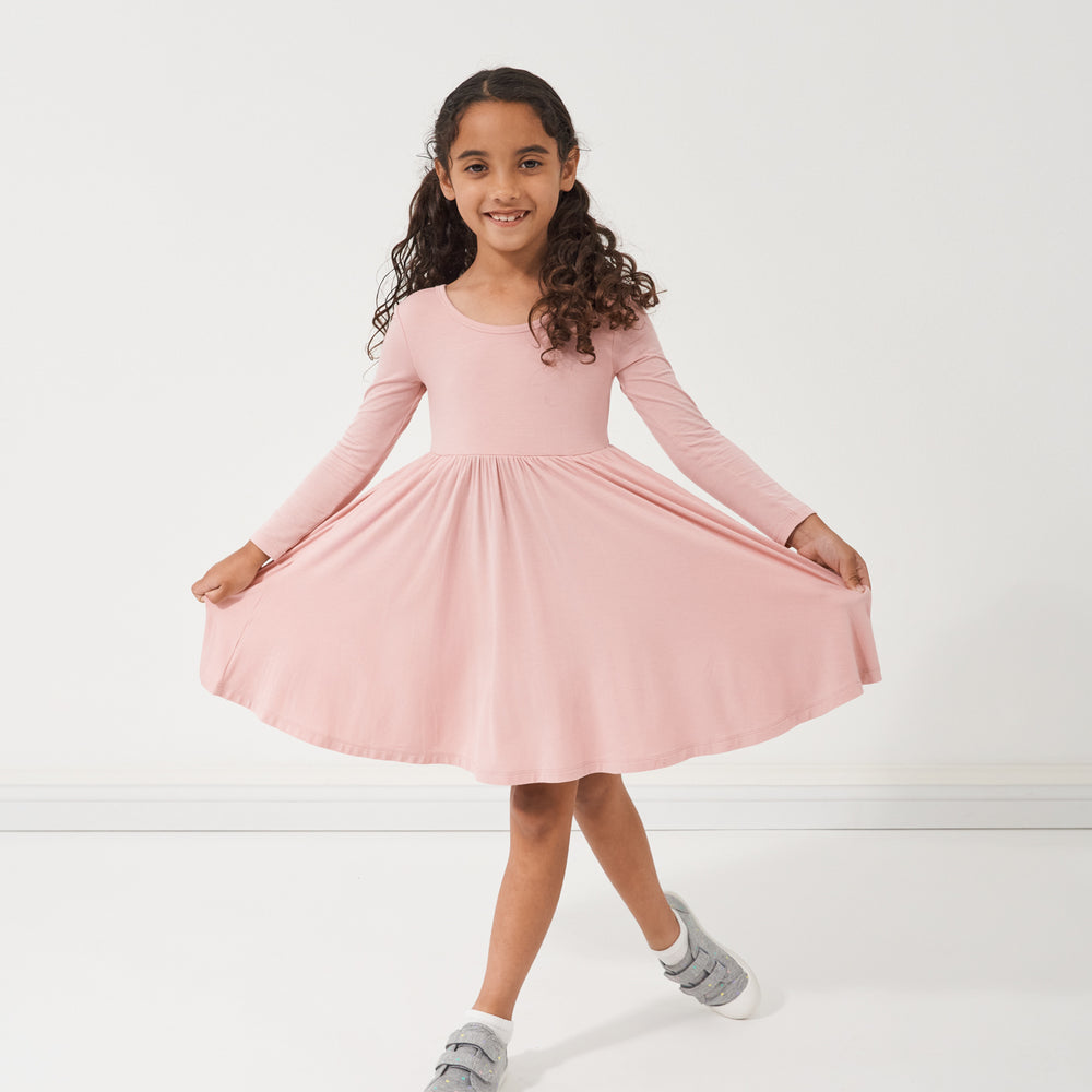 Child curtseying wearing a Mauve Blush twirl dress