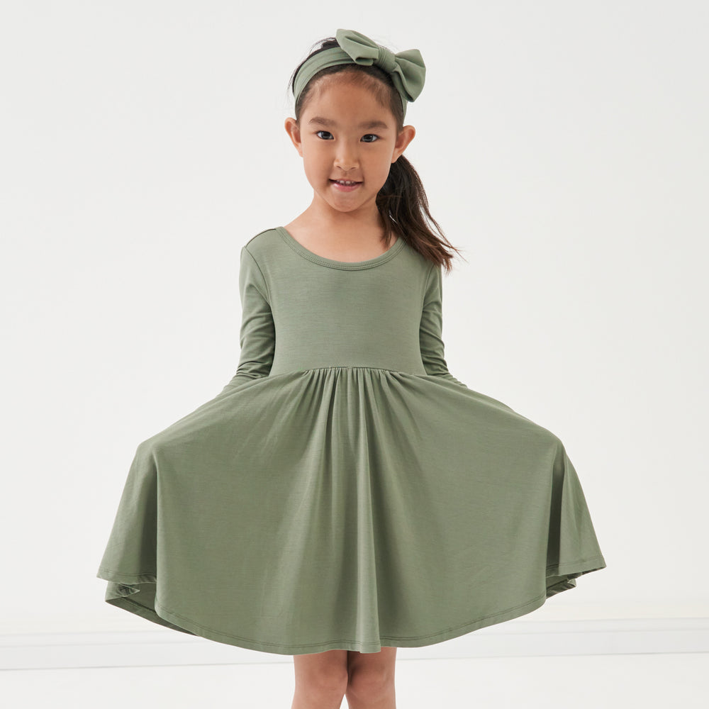 Click to see full screen - Child wearing a Moss luxe bow headband and matching twirl dress