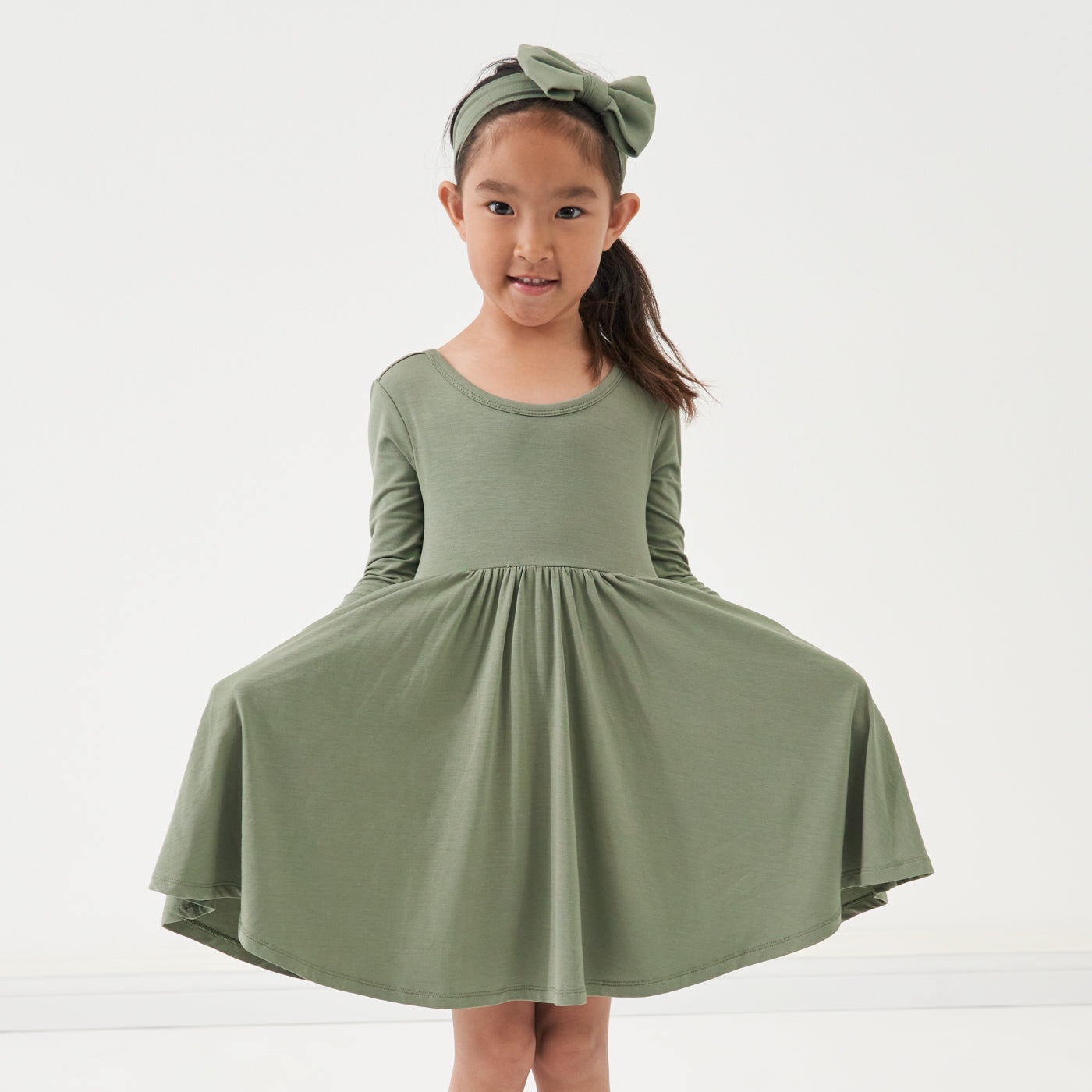 Child wearing a Moss luxe bow headband and matching twirl dress