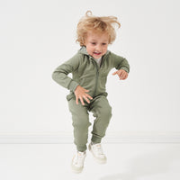 Child jumping in the air wearing a Moss zip hoodie and matching jogger