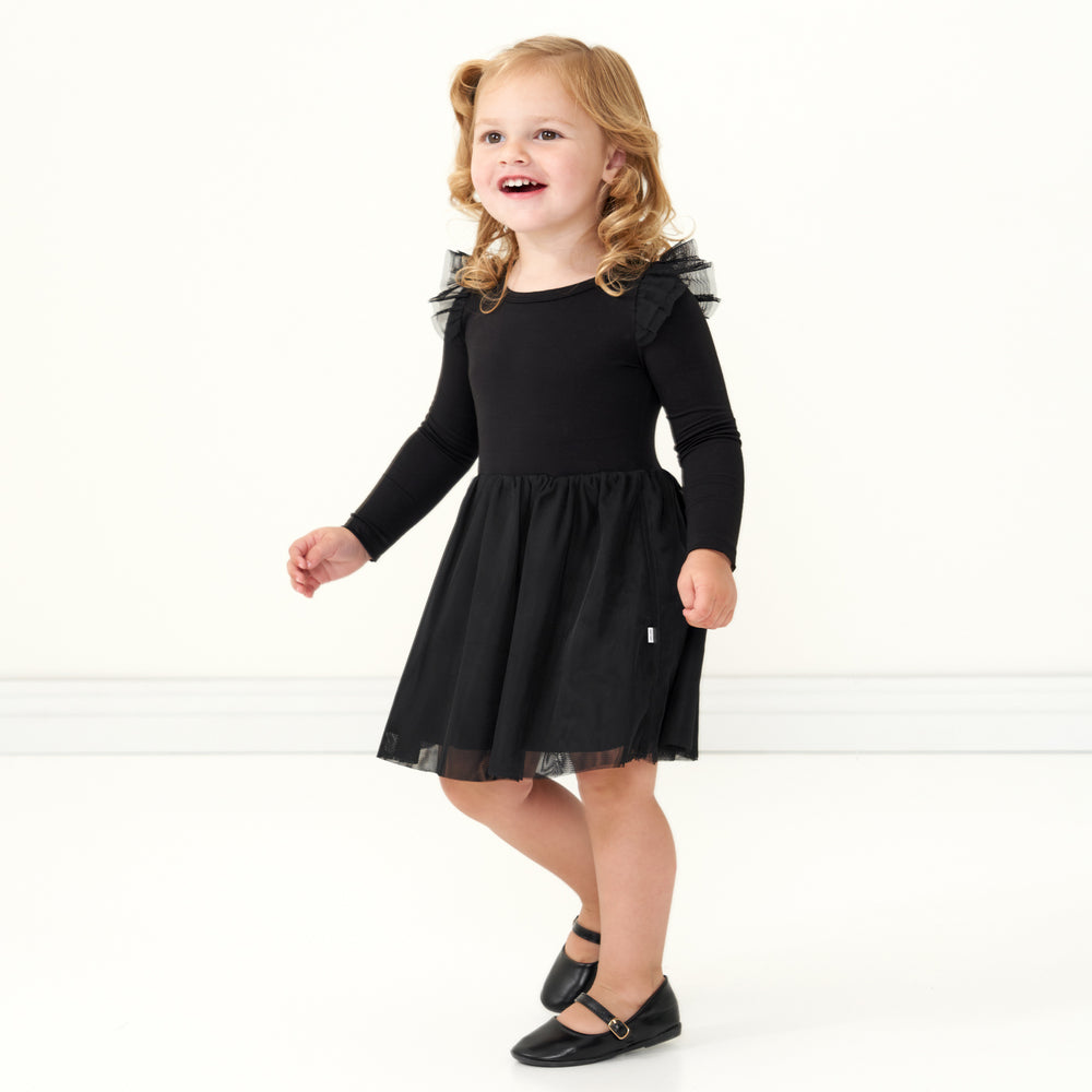 Child walking wearing a Black flutter tutu dress with bloomer