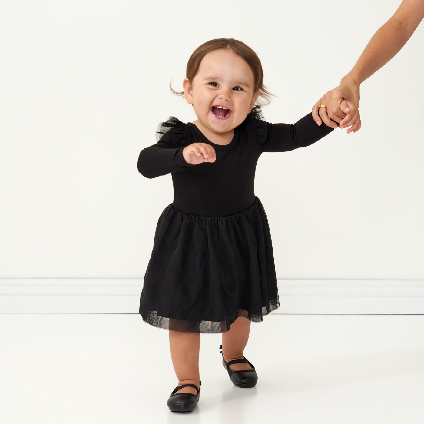 Child holding a parent's hand wearing a Black flutter tutu dress with bloomer