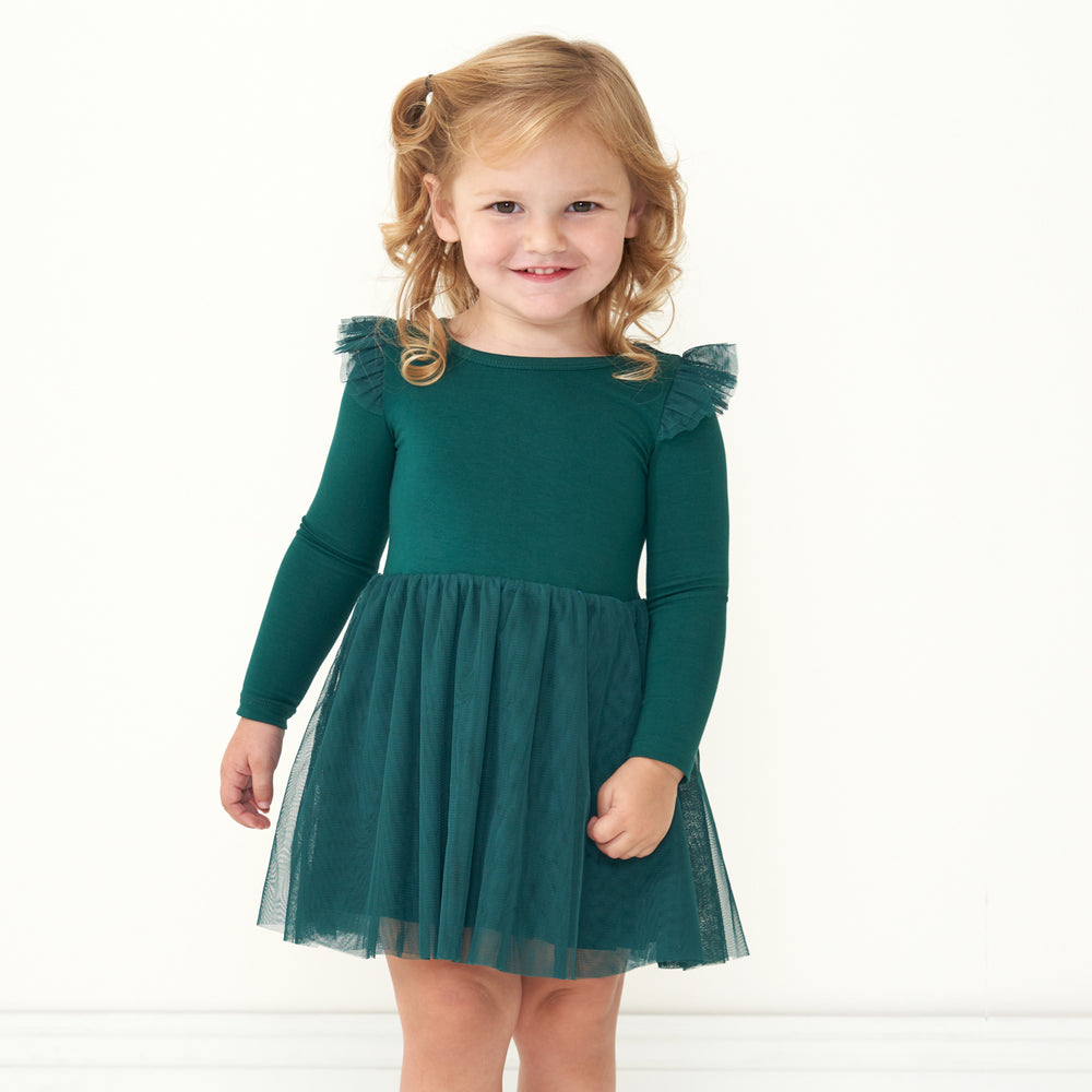 Child posing wearing an Emerald flutter tutu dress with bloomer