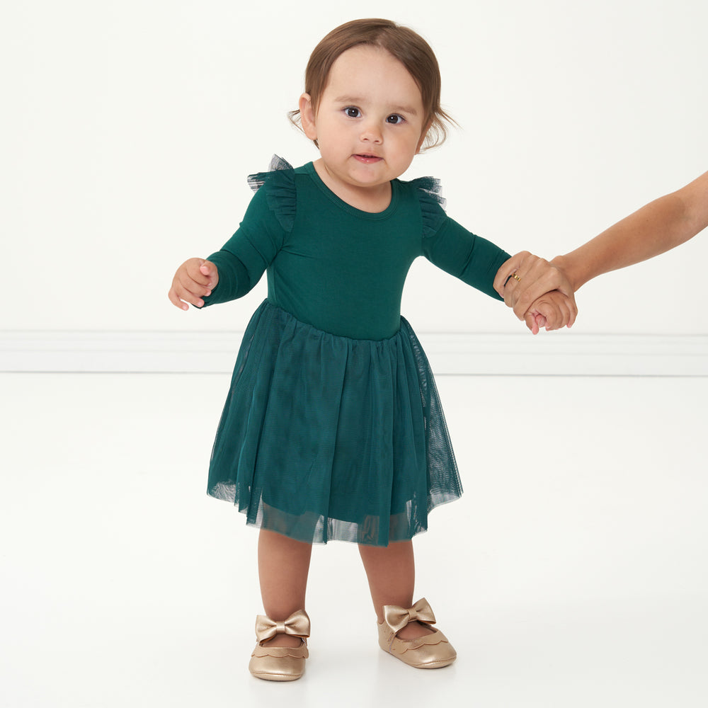 Child holding their mother's hand wearing an Emerald flutter tutu dress with bloomer