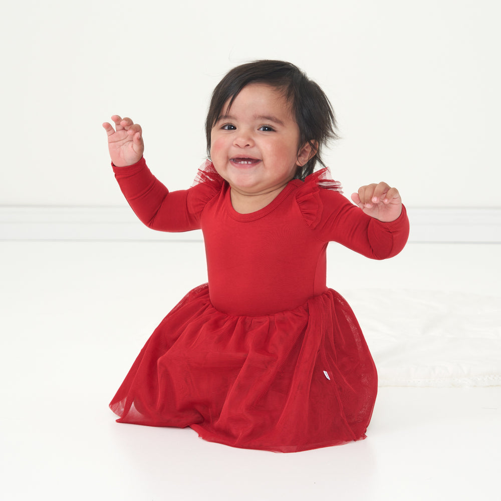Child sitting wearing a Holiday Red flutter tutu dress with bloomer