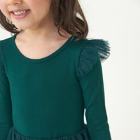 Close up image of a child wearing an Emerald flutter tutu dress showing off the flutter sleeve detail