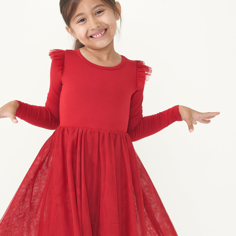 Child posing wearing a Holiday Red flutter tutu dress