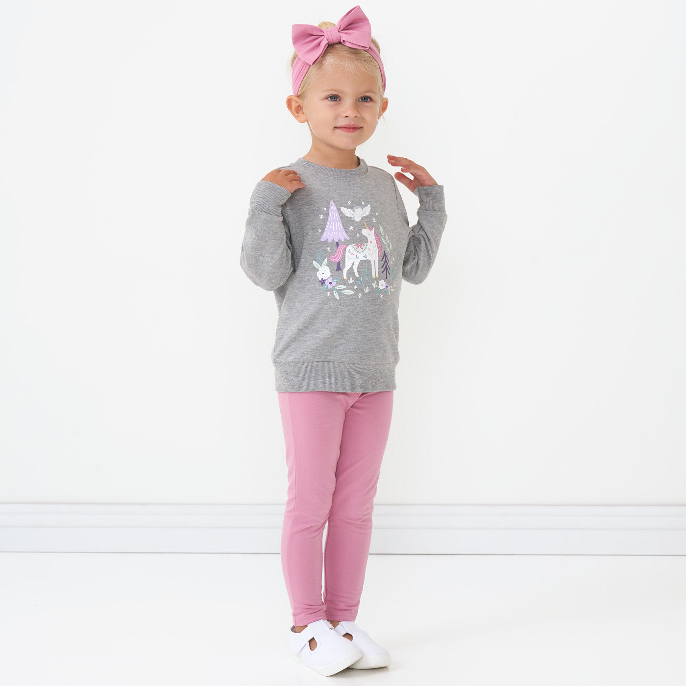 Child wearing Garden Rose Cozy Leggings paired with winter collection play styles and a luxe bow headband