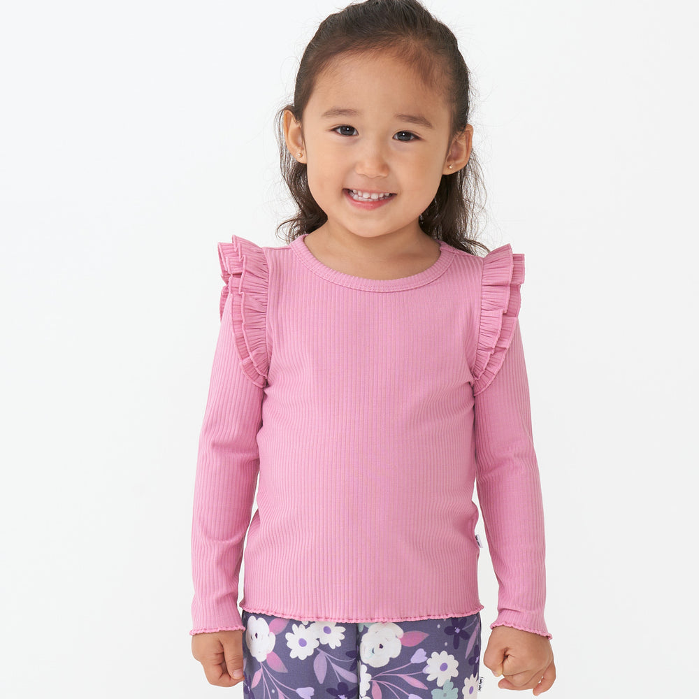 Close up image of a child wearing a Garden Rose ribbed flutter tee paired with Sugar Plum Floral leggings