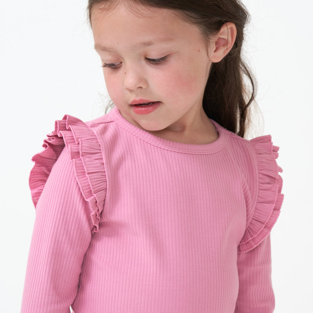 Close up image of a child wearing a Garden Rose ribbed flutter tee 
