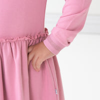 Close up image of a child wearing a Garden Rose drop waist dress focusing on the waistline and sleeve cuffs