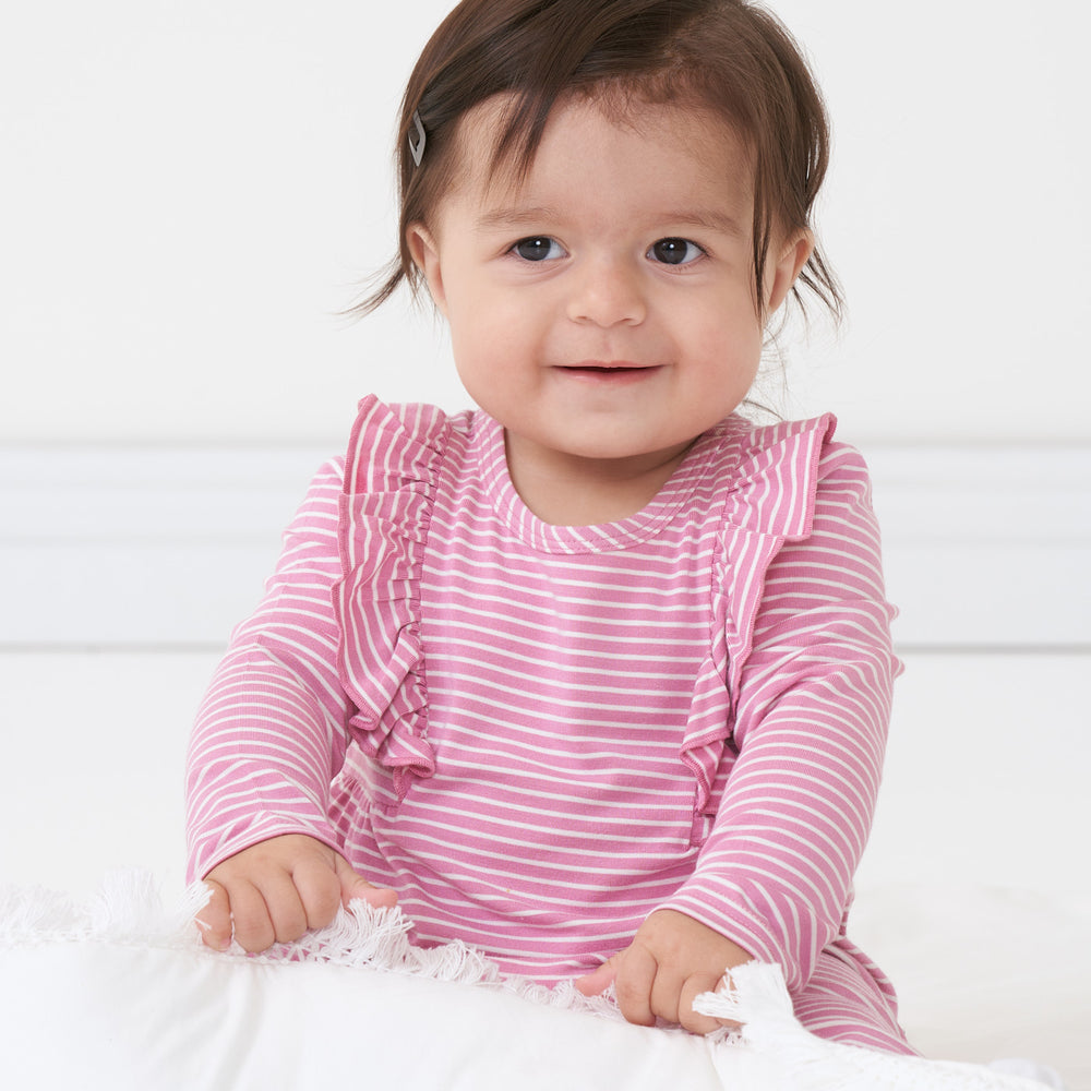 Alternate close up image of a child sitting wearing a Garden Rose stripe ruffle bib romper