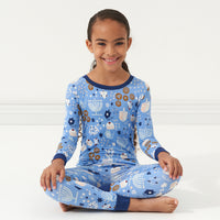 Child sitting wearing Hanukkah Lights and Love two piece pajama set