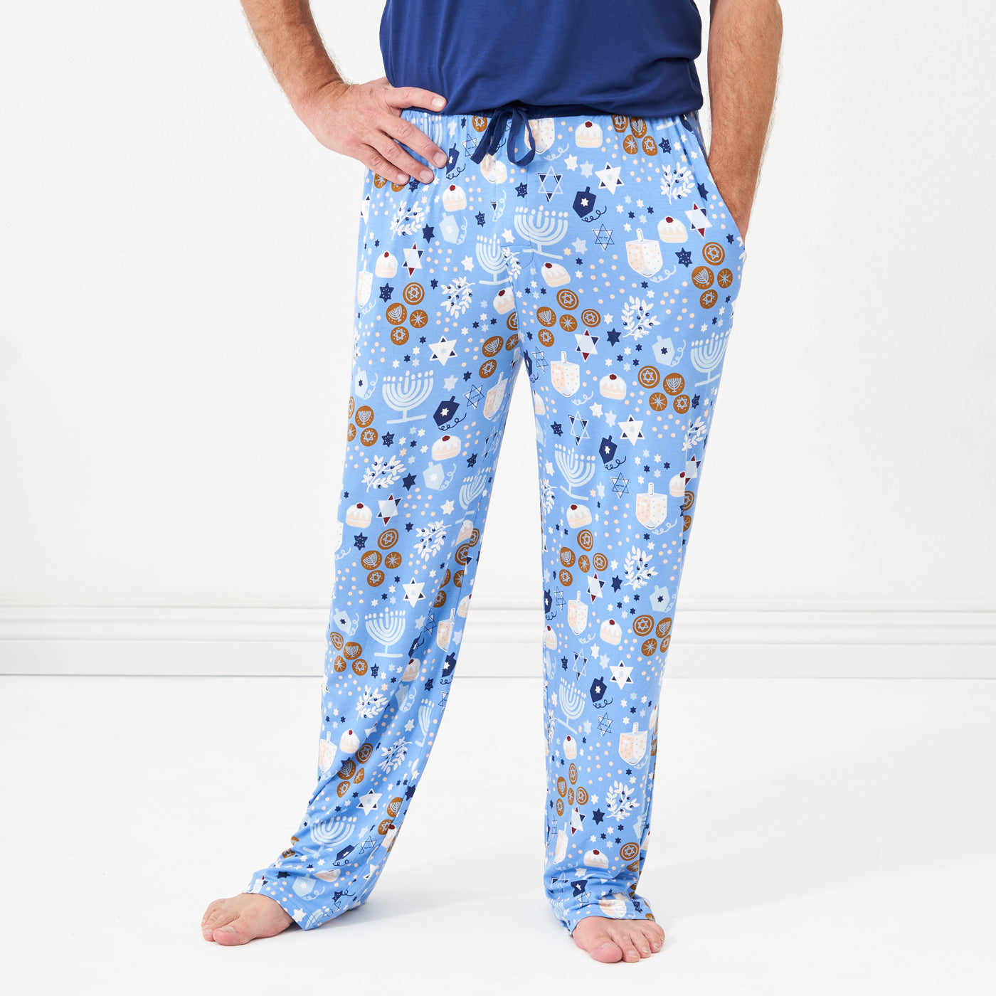 Close up image of a man posing wearing a Hanukkah Lights and Love men's pajama pants paired with a men's Sapphire short sleeve pajama top