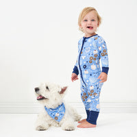 Alternative image of a small white dog wearing a Hanukkah Lights and Love pet bandana. Next to him is a small child wearing a matching Hanukkah Lights and Love zippy