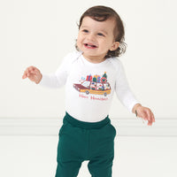 Child wearing a Happy Howlidays graphic bodysuit and coordinating Emerald joggers