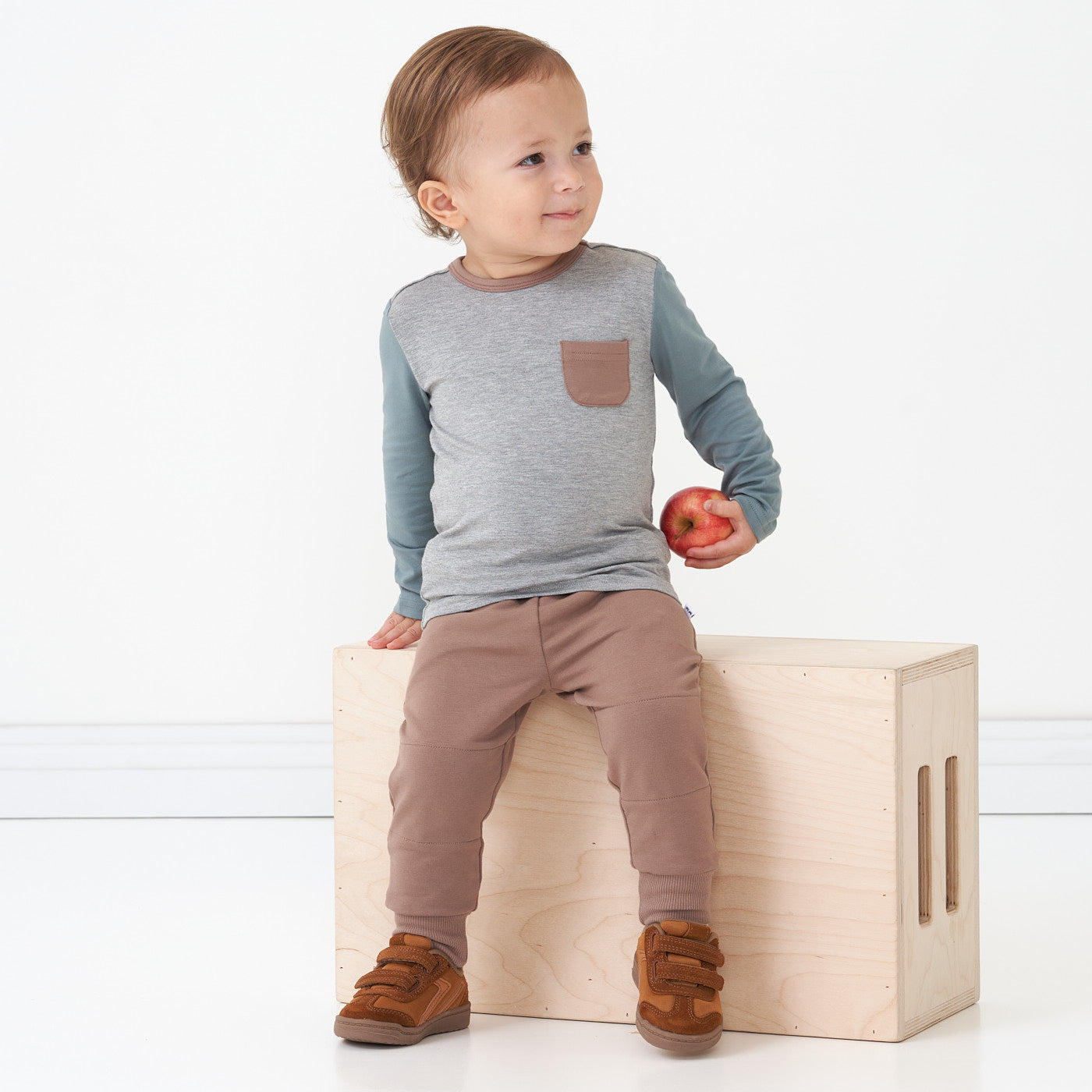 Alternate image of a child sitting on a bench wearing a Colorblock Pocket tee paired with Light Cocoa joggers