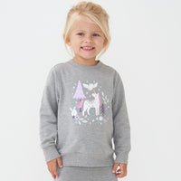 Close up image of a child wearing a Unicorn crewneck sweatshirt paired with heather gray cozy leggings