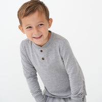Child posing wearing a Heather Gray henley tee