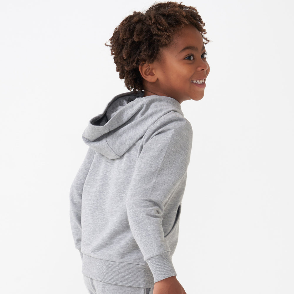 Profile view of a child wearing a Heather Gray pullover hoodie