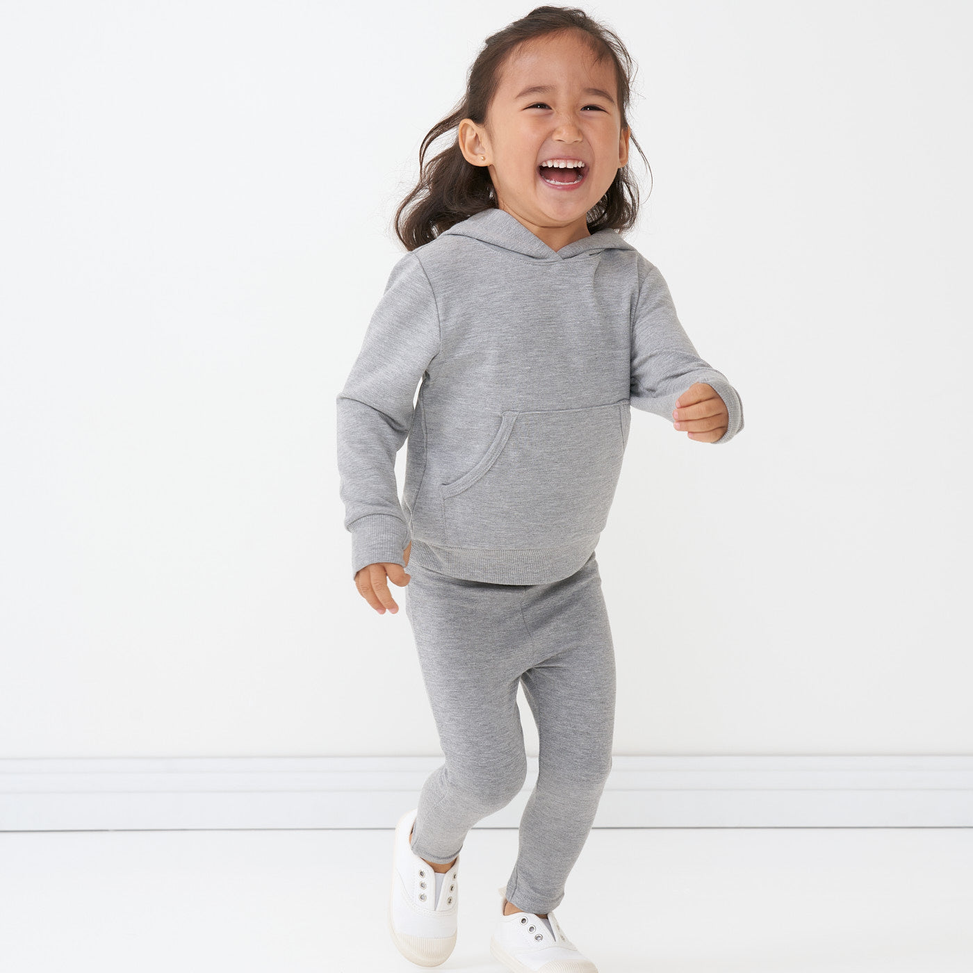 Child wearing a Heather Gray pullover hoodie paired with Heather Gray cozy leggings