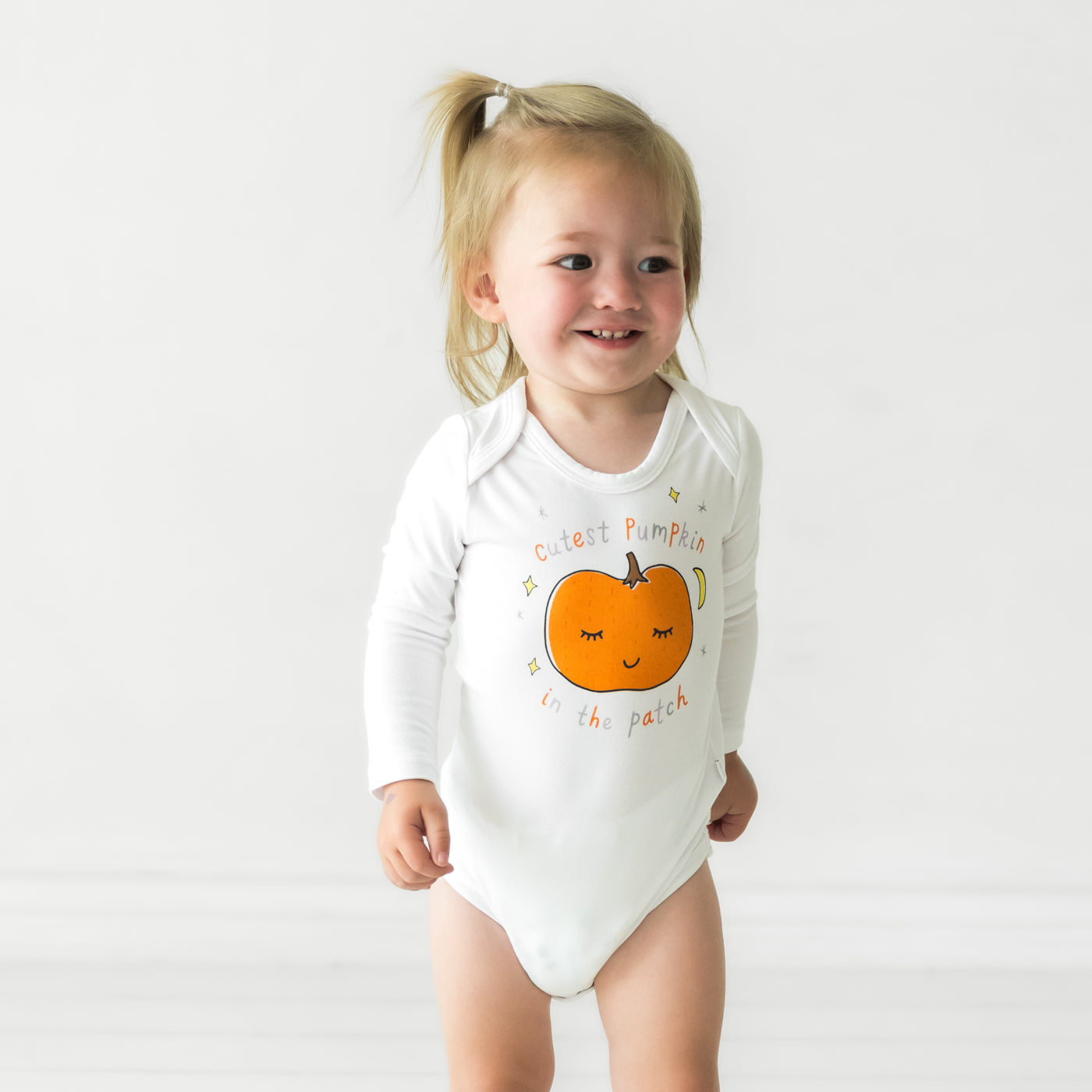 Child wearing a Little Pumpkin graphic bodysuit
