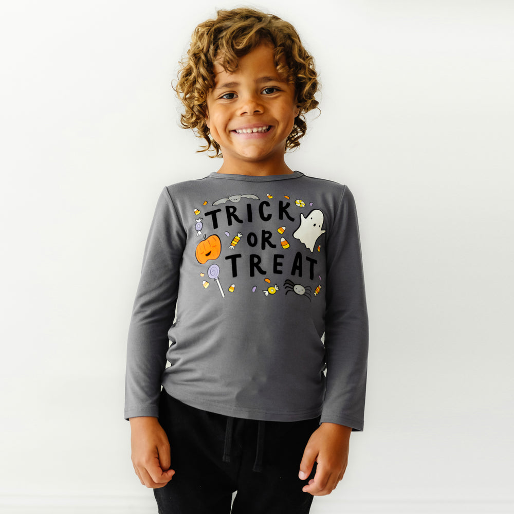 Close up image of a child wearing a Trick or Treat graphic tee paired with Black Joggers
