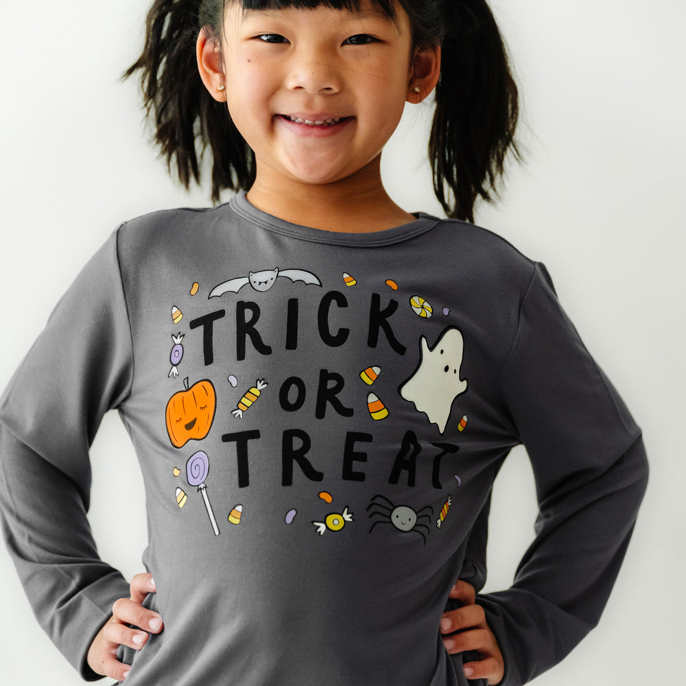 Close up image of a child wearing a Trick or Treat graphic tee 