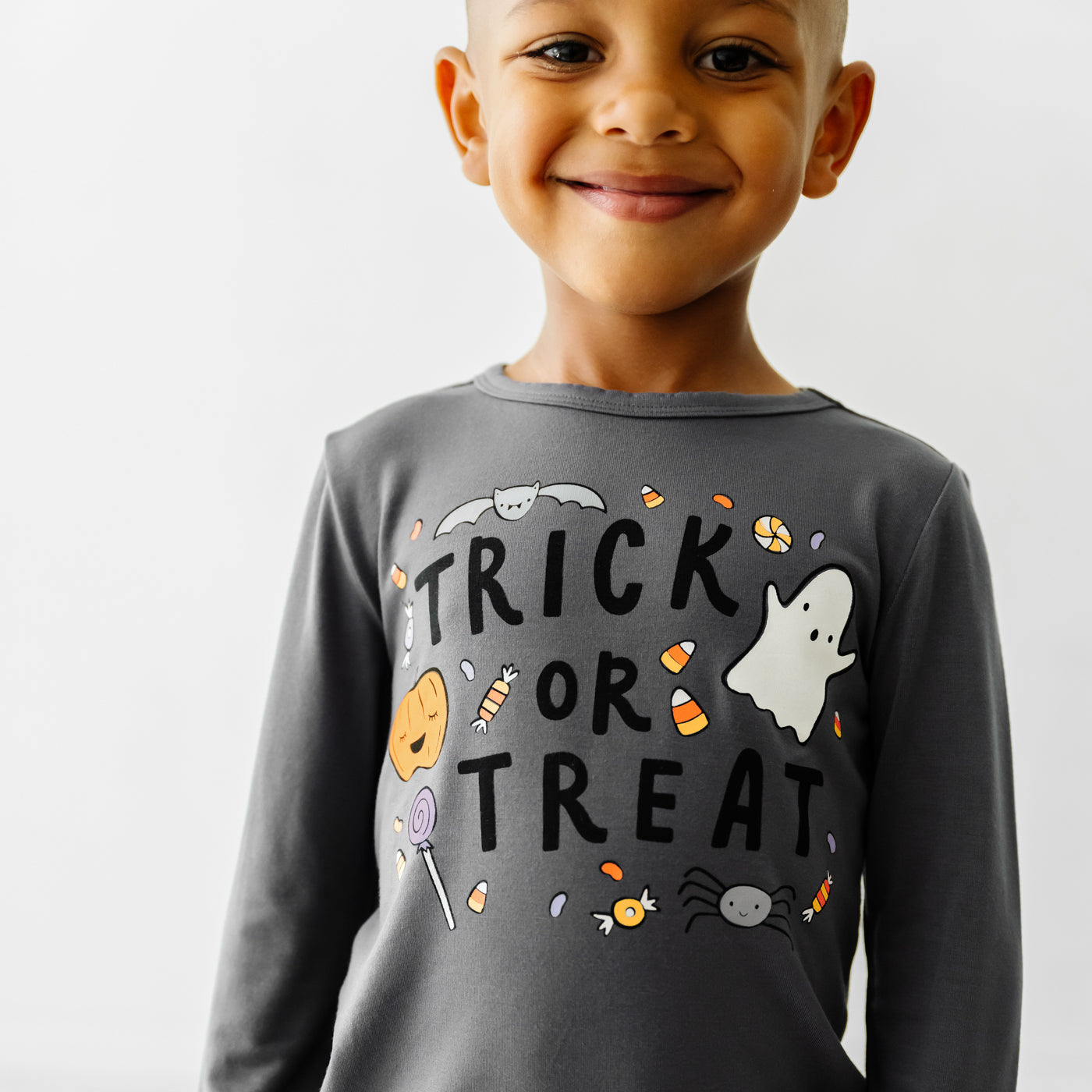 Close up image of a child wearing a Trick or Treat graphic tee