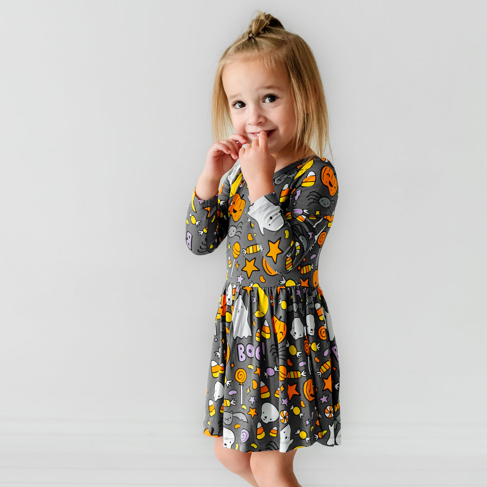 Child posing wearing a Hey Boo printed twirl dress with bodysuit