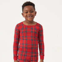 Close up image of a child wearing a Holiday Plaid two piece pajama set