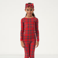 Alternate image of a child wearing a Holiday Plaid two piece pajama set and matching luxe bow headband