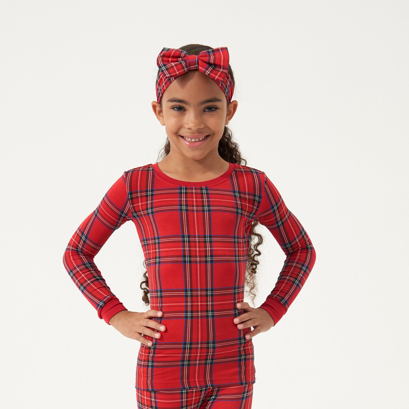 Child wearing a Holiday Plaid luxe bow headband and matching pajamas
