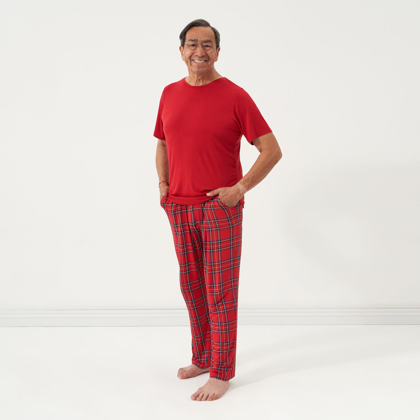 Man wearing Holiday Plaid men's pajama pants and coordinating Holiday Red top