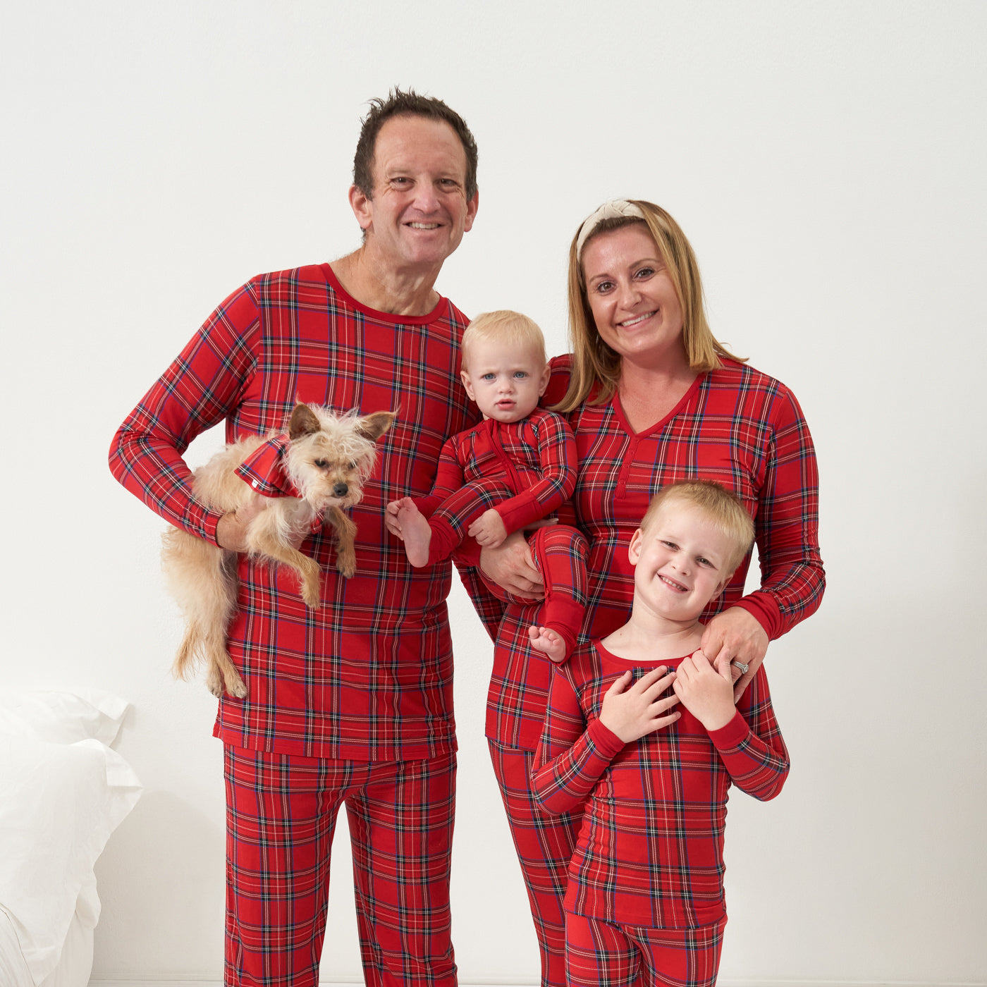 Family and dog wearing matching Holiday Plaid pajamas and pet bandana