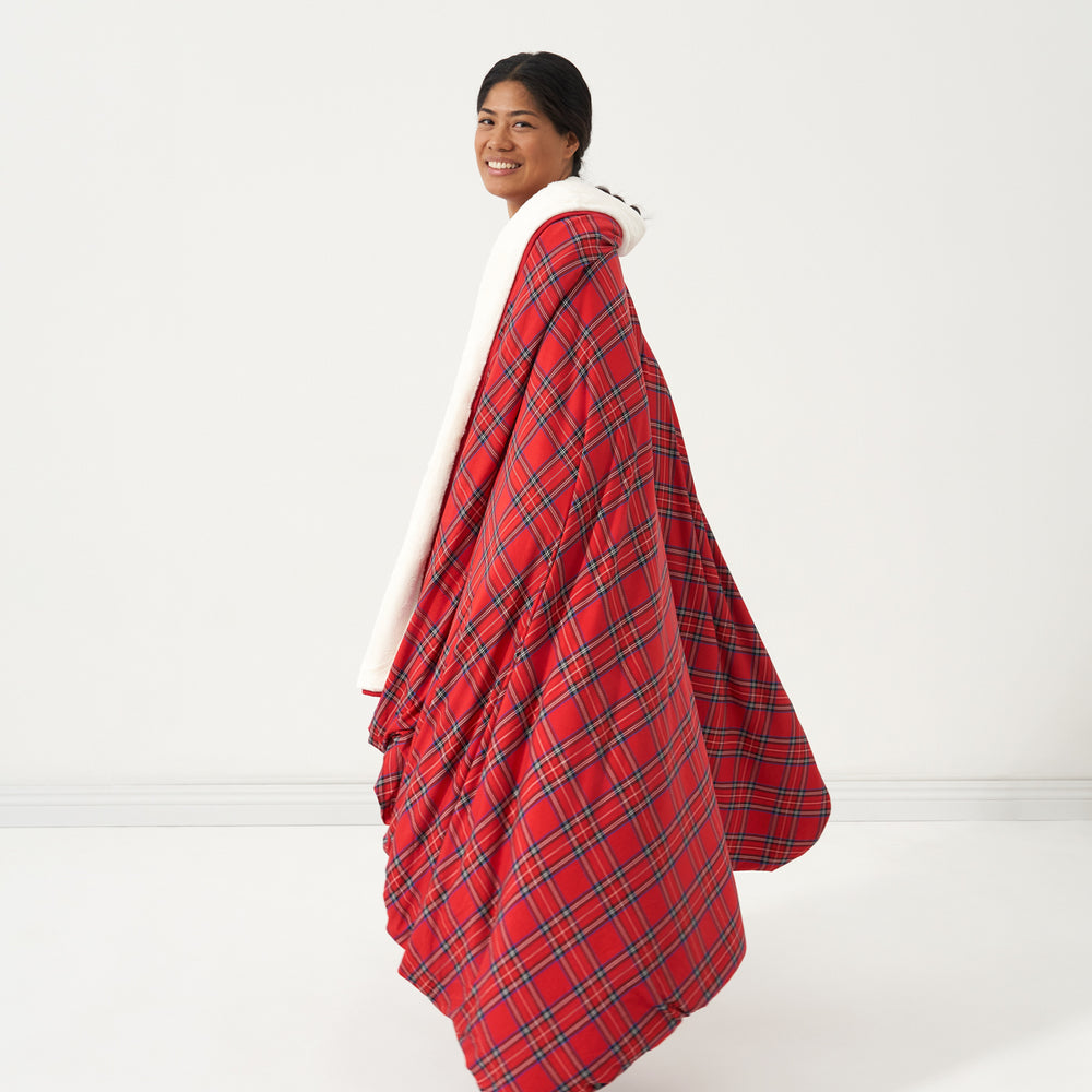 Side view image of a woman wrapped up in a Holiday Plaid plush oversized cloud blanket