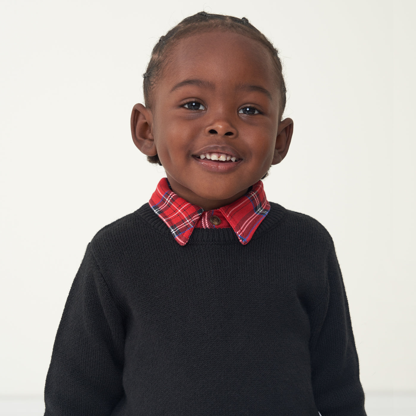 Child wearing a Holiday Plaid polo shirt and coordinating Black knit sweater