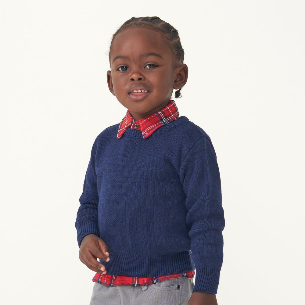 Child wearing a Holiday Plaid polo shirt and coordinating Classic Navy knit sweater